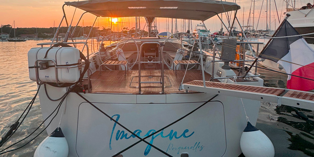Yacht amarré la nuit dans le port de Porquerolles, lumières dorées